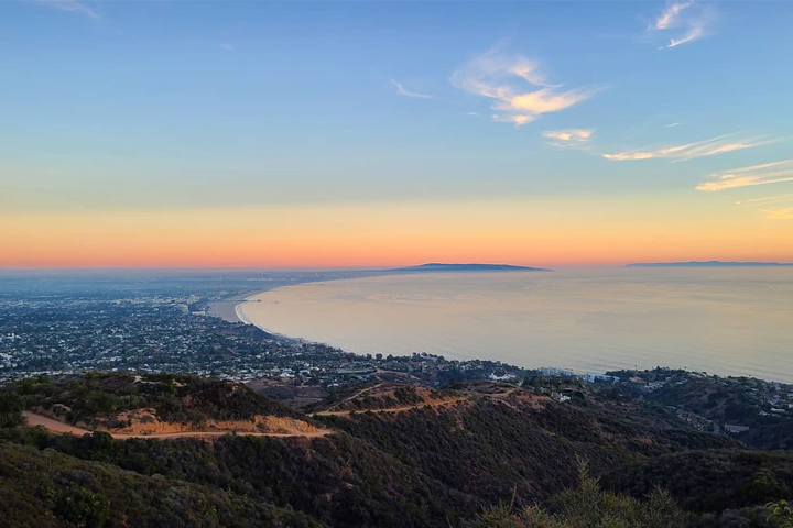 The view of the Santa Monica coast at sunset from the top of a mountain.